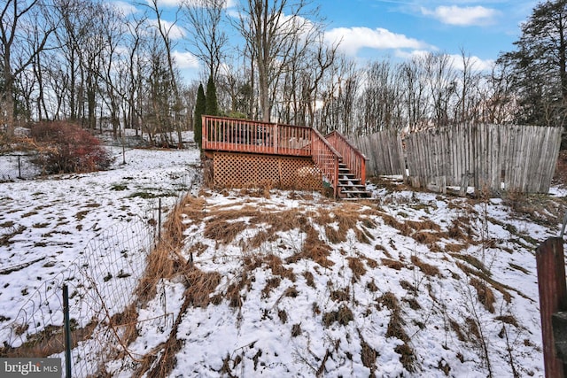 yard covered in snow with a wooden deck