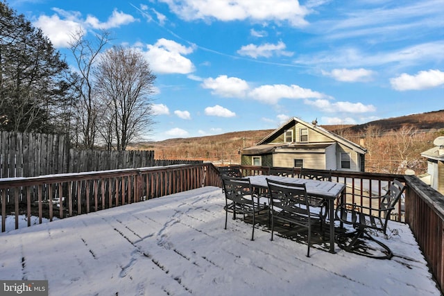 snow covered deck with a mountain view