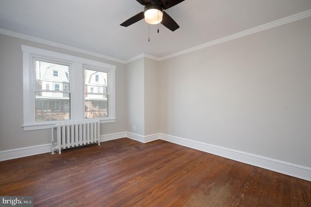 spare room featuring ceiling fan, dark hardwood / wood-style flooring, radiator heating unit, and crown molding