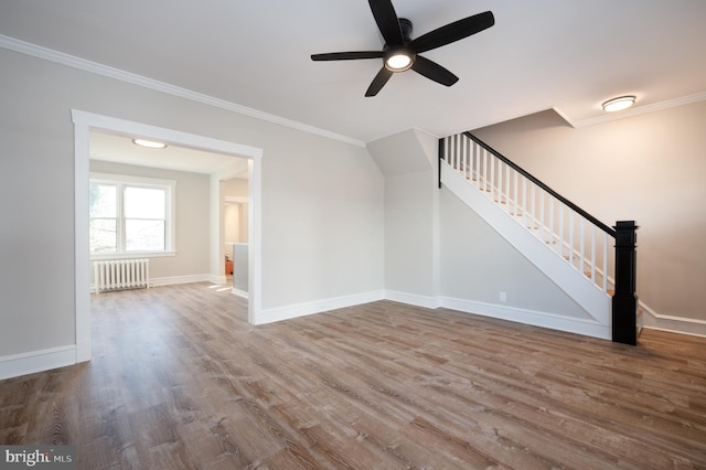 unfurnished living room with hardwood / wood-style floors, ceiling fan, crown molding, and radiator