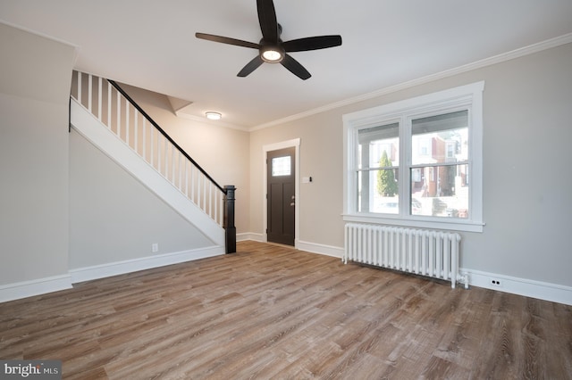 entrance foyer with radiator heating unit, light hardwood / wood-style flooring, ceiling fan, and ornamental molding