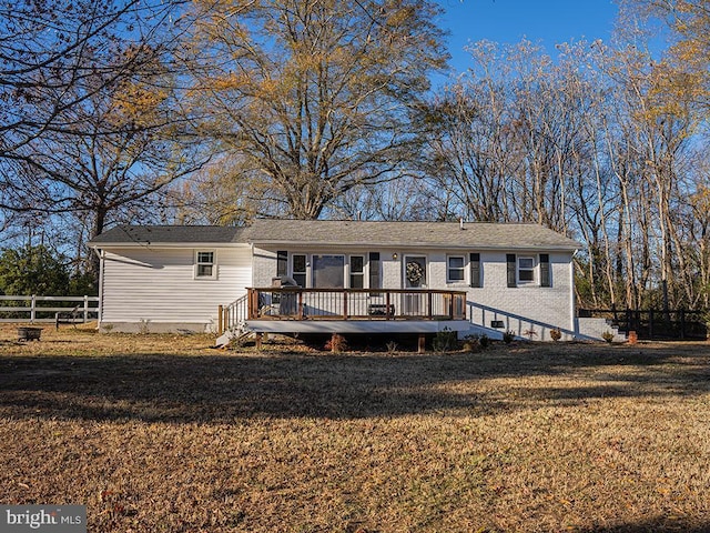 view of front of house with a wooden deck and a front lawn