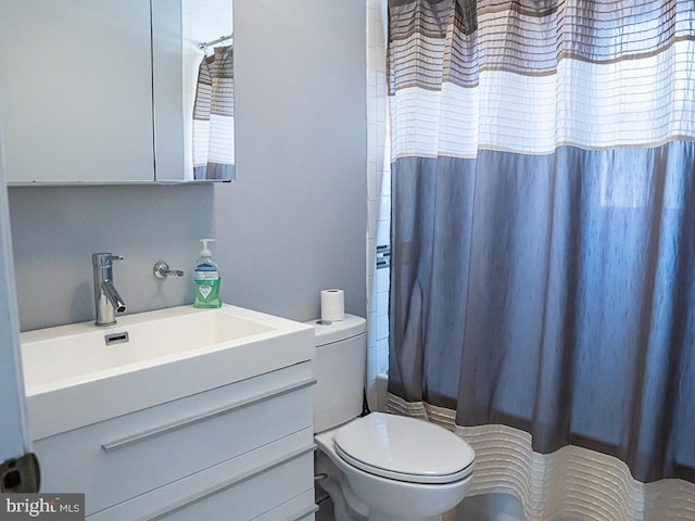 full bathroom featuring shower / bath combo with shower curtain, vanity, and toilet