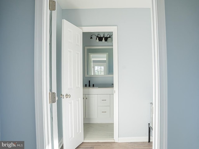 hall with hardwood / wood-style floors and sink