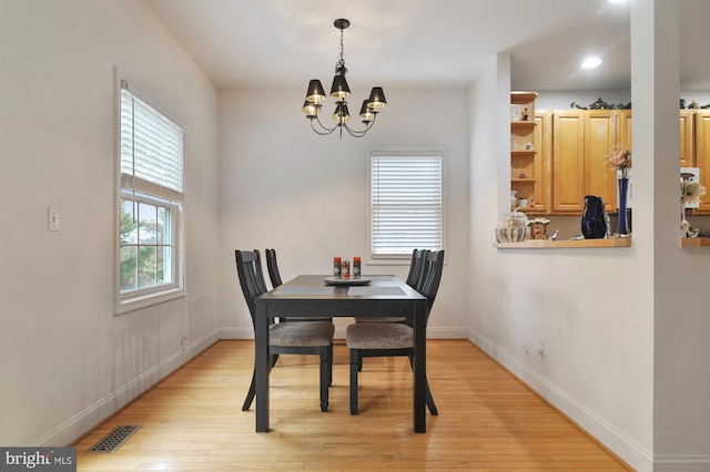 dining room featuring light wood-type flooring and a chandelier