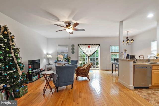 living room featuring sink, light hardwood / wood-style floors, and ceiling fan with notable chandelier