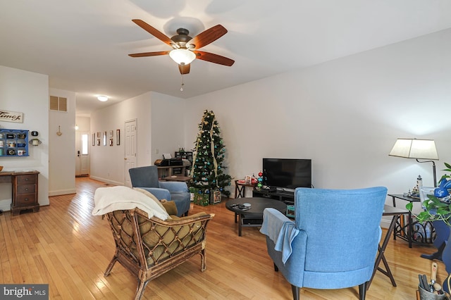 living room featuring ceiling fan and light hardwood / wood-style flooring