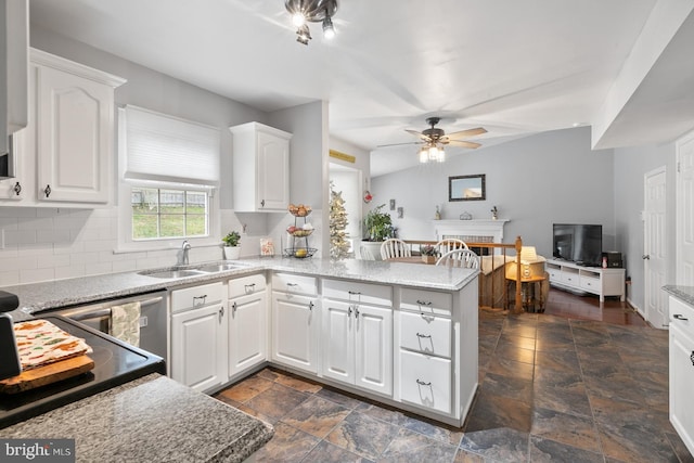 kitchen featuring white cabinets, sink, ceiling fan, decorative backsplash, and kitchen peninsula