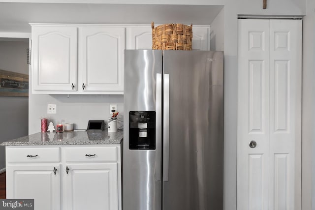 kitchen featuring white cabinets, stone countertops, and stainless steel refrigerator with ice dispenser