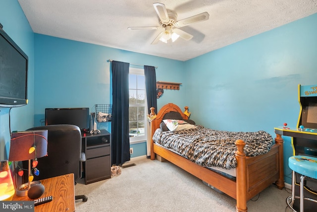 bedroom featuring ceiling fan, light colored carpet, and a textured ceiling