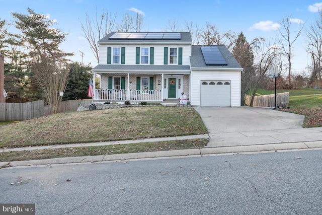 view of front of house featuring a front yard, solar panels, a porch, and a garage