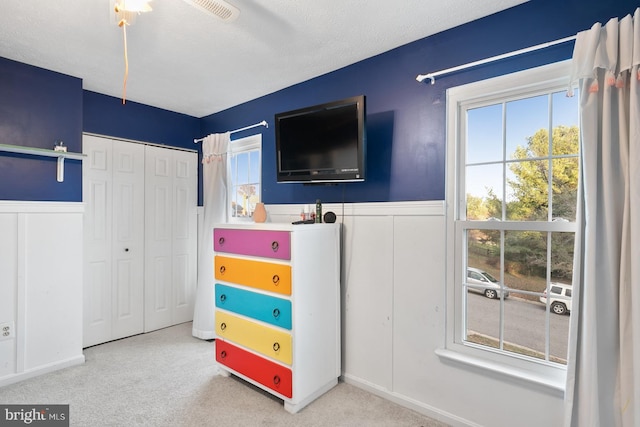 bedroom featuring a textured ceiling, carpet floors, a closet, and ceiling fan