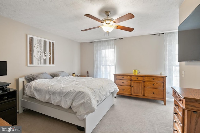 carpeted bedroom featuring a textured ceiling and ceiling fan