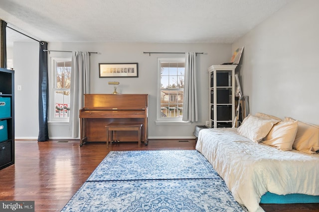 bedroom with dark hardwood / wood-style flooring and a textured ceiling