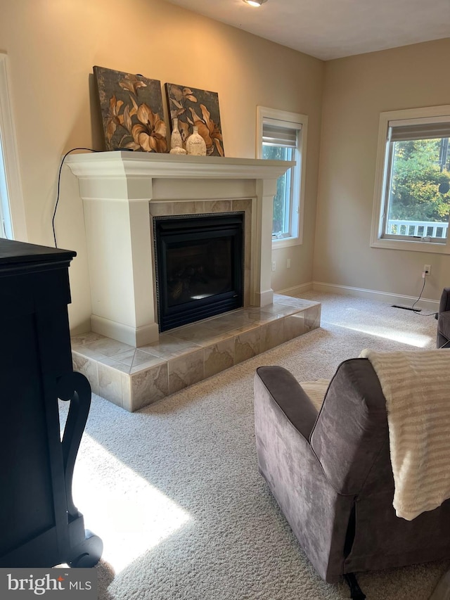 carpeted living area with baseboards and a tiled fireplace