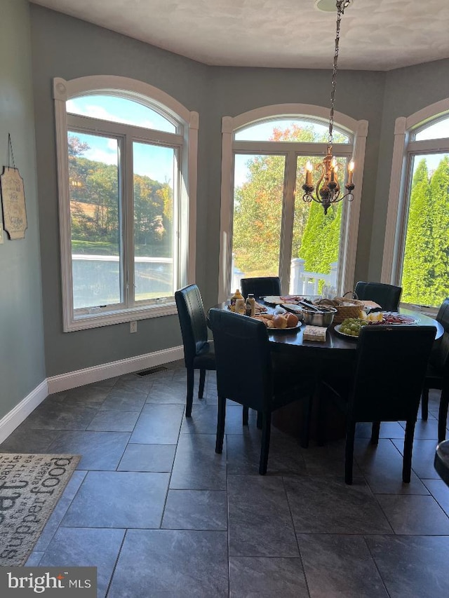 dining area with an inviting chandelier and baseboards