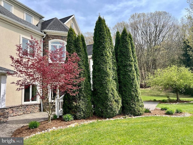 view of side of home with a yard