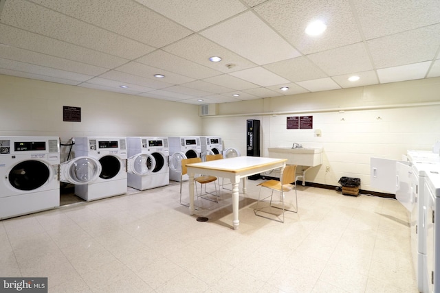 clothes washing area featuring washer and clothes dryer and sink