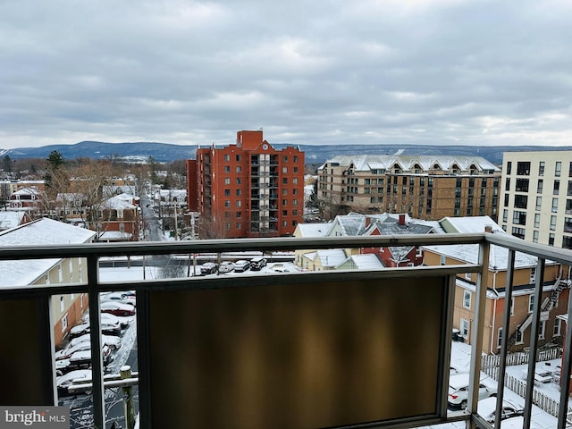 snow covered back of property featuring a mountain view