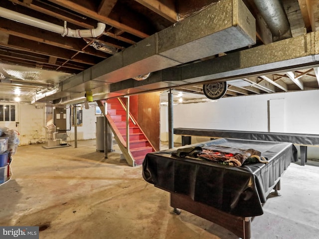 basement featuring electric panel, gas water heater, and heating unit