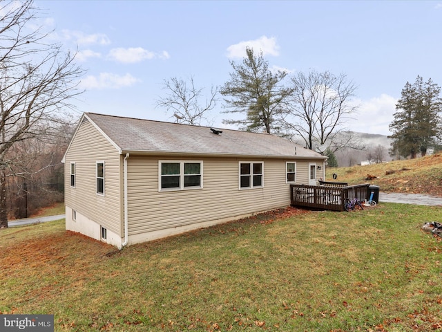 view of side of property with a lawn and a deck