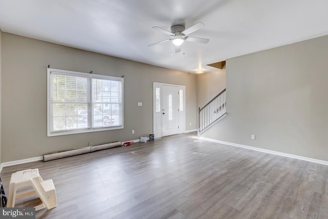 interior space with ceiling fan, a baseboard heating unit, and light wood-type flooring