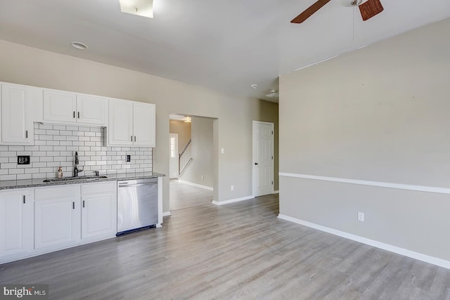 kitchen with white cabinetry, sink, stainless steel dishwasher, and decorative backsplash