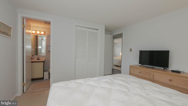 carpeted bedroom featuring sink, connected bathroom, and a closet