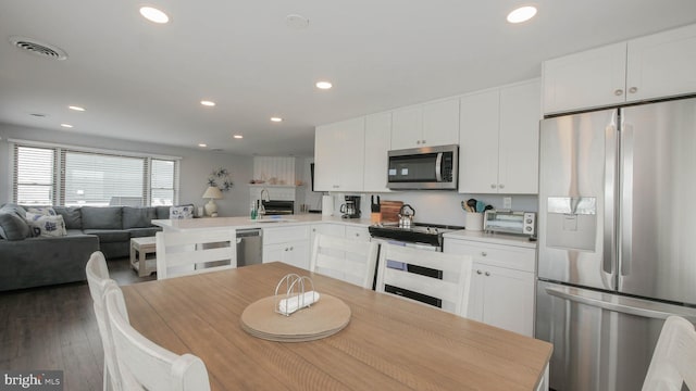 kitchen featuring white cabinetry, dark hardwood / wood-style flooring, stainless steel appliances, and sink