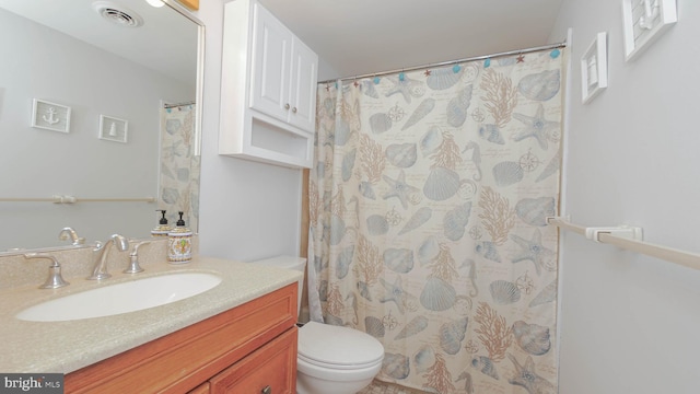 bathroom featuring walk in shower, vanity, and toilet