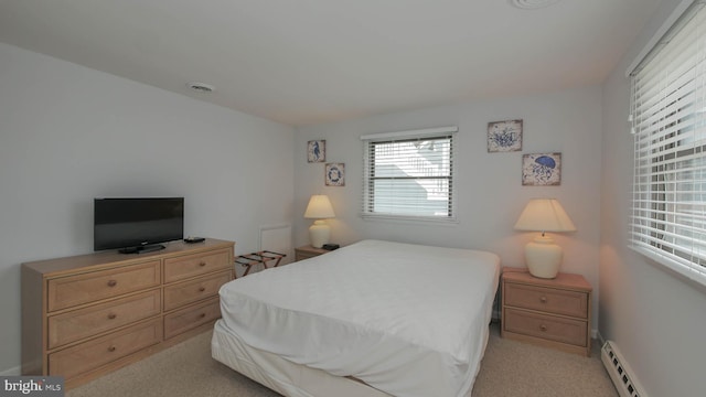 carpeted bedroom featuring a baseboard heating unit