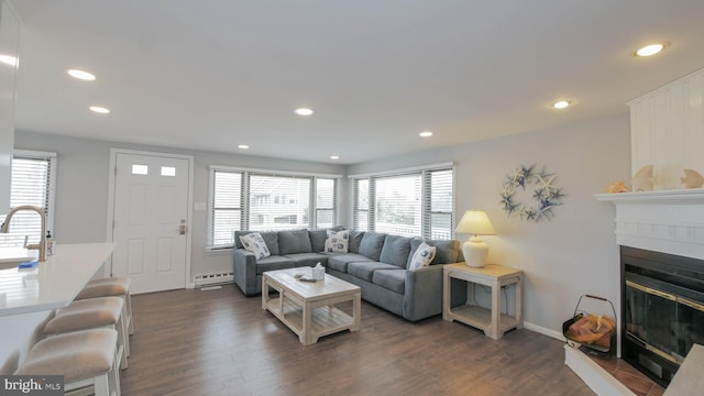 living room with sink, dark wood-type flooring, and a baseboard radiator