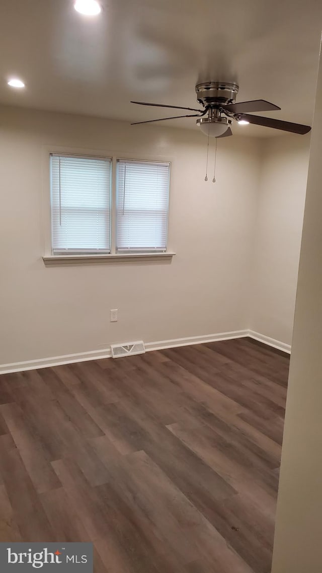 unfurnished room with dark hardwood / wood-style floors and ceiling fan