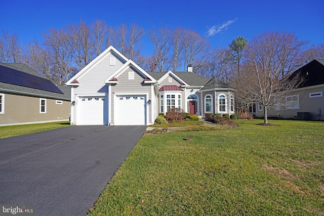 view of front of home featuring central AC, a front lawn, and a garage