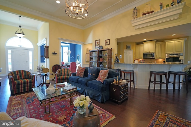 living room with crown molding, dark hardwood / wood-style floors, and an inviting chandelier