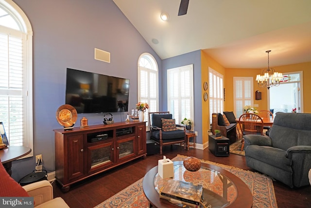 living room with ceiling fan with notable chandelier, dark hardwood / wood-style flooring, and high vaulted ceiling