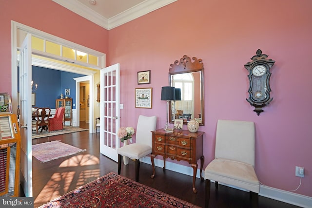 sitting room featuring french doors, crown molding, and dark wood-type flooring