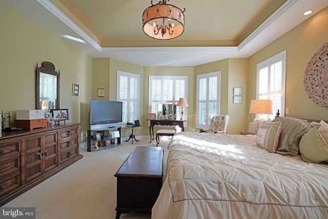 bedroom with an inviting chandelier, light carpet, a tray ceiling, and multiple windows