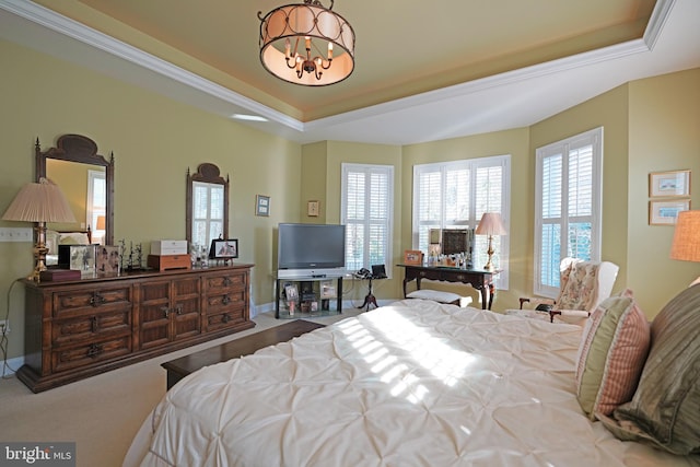 carpeted bedroom with a tray ceiling, multiple windows, and a notable chandelier