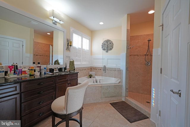 bathroom with vanity, tile patterned flooring, and plus walk in shower