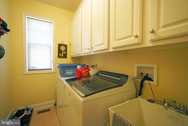 laundry area featuring cabinets, washing machine and dryer, tile patterned flooring, and sink