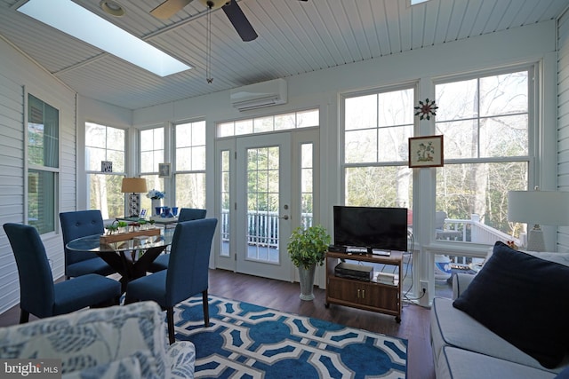 sunroom / solarium featuring a wall unit AC, a skylight, and ceiling fan