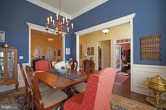 dining room featuring ornamental molding, dark wood-type flooring, and an inviting chandelier