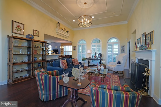 living room with a healthy amount of sunlight, crown molding, dark wood-type flooring, and an inviting chandelier