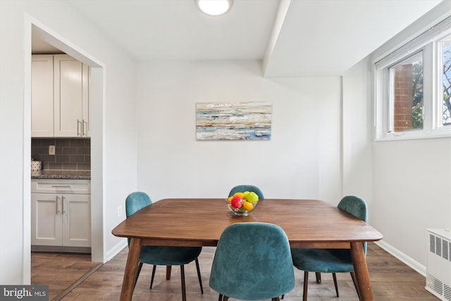 dining room featuring hardwood / wood-style floors and radiator