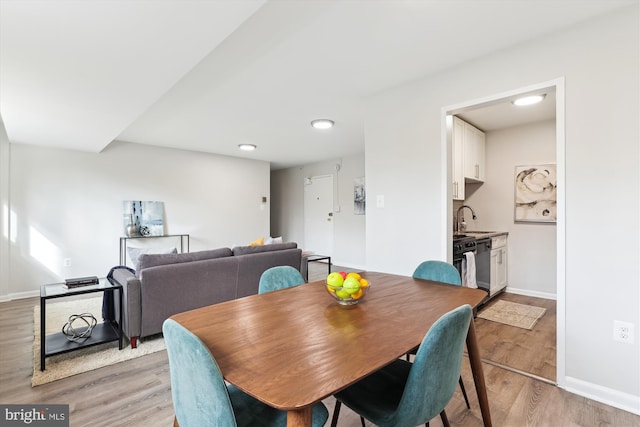 dining area with light wood-type flooring and sink