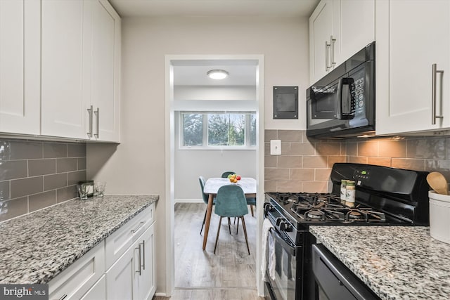 kitchen featuring white cabinets, light hardwood / wood-style floors, and black appliances