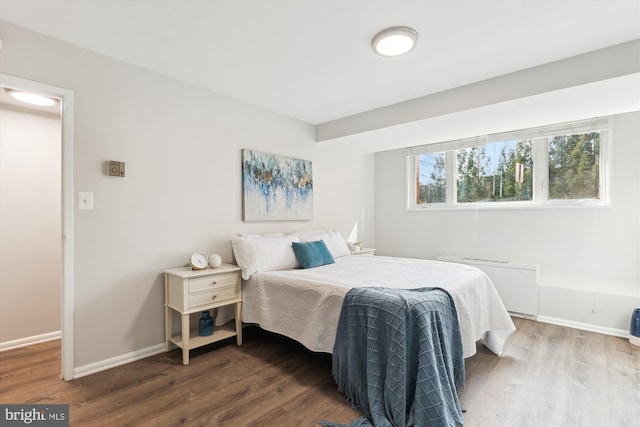 bedroom with dark hardwood / wood-style floors