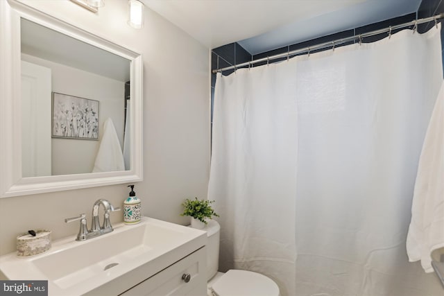 bathroom with vanity, curtained shower, and toilet