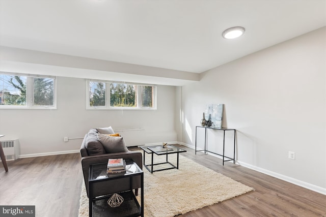 living area featuring hardwood / wood-style floors, a healthy amount of sunlight, and radiator